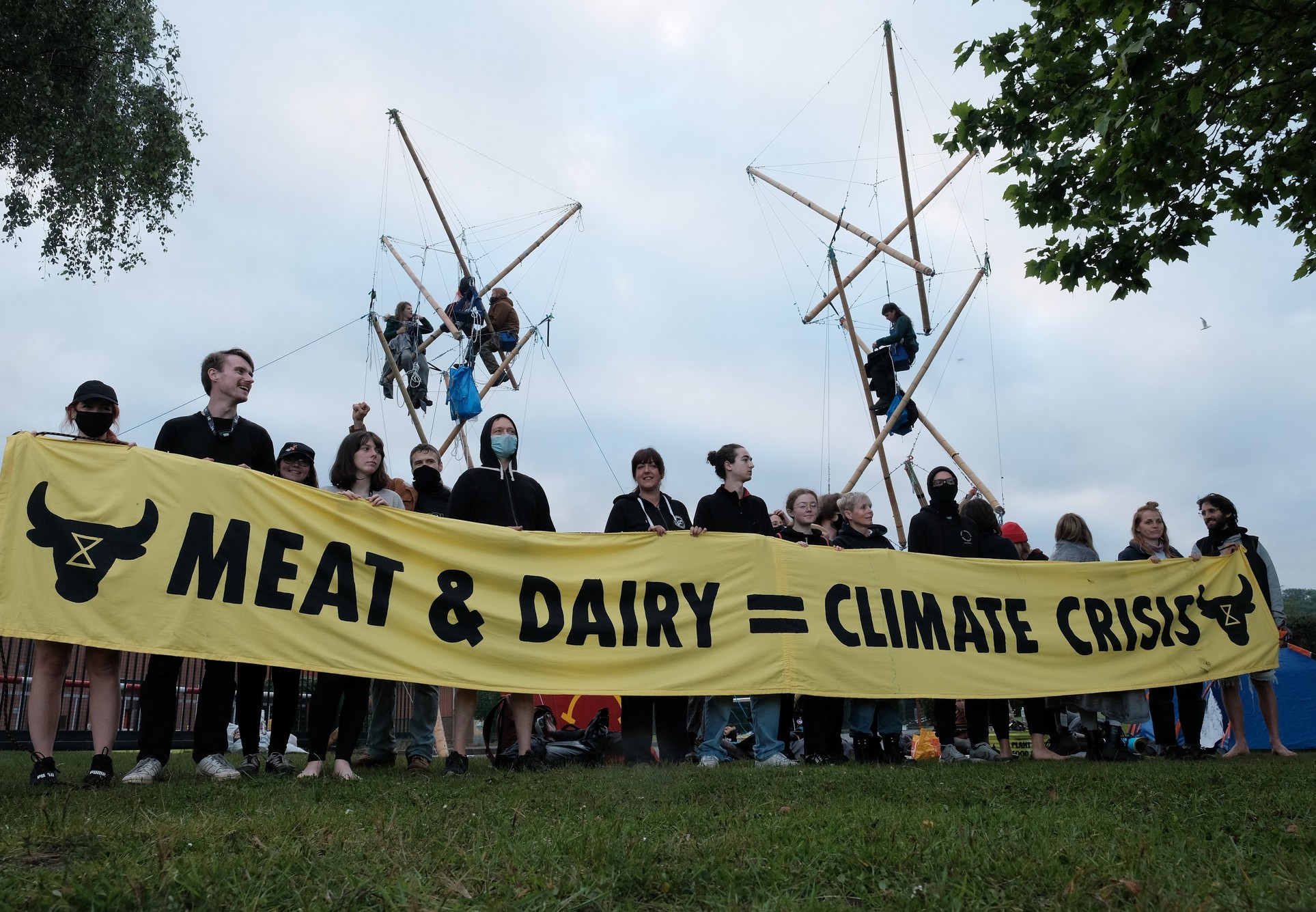 Animal Rebellion holding a banner, saying meat & dairy = climate crisis.