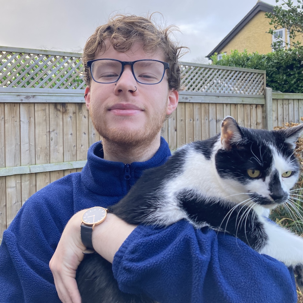 Photo of Nathan McGovern holding a black and white cat